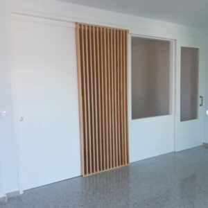 puerta corredera lacada en blanco con panel separador de lamas de madera a medida