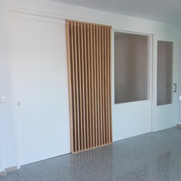 puerta corredera lacada en blanco con panel separador de lamas de madera a medida